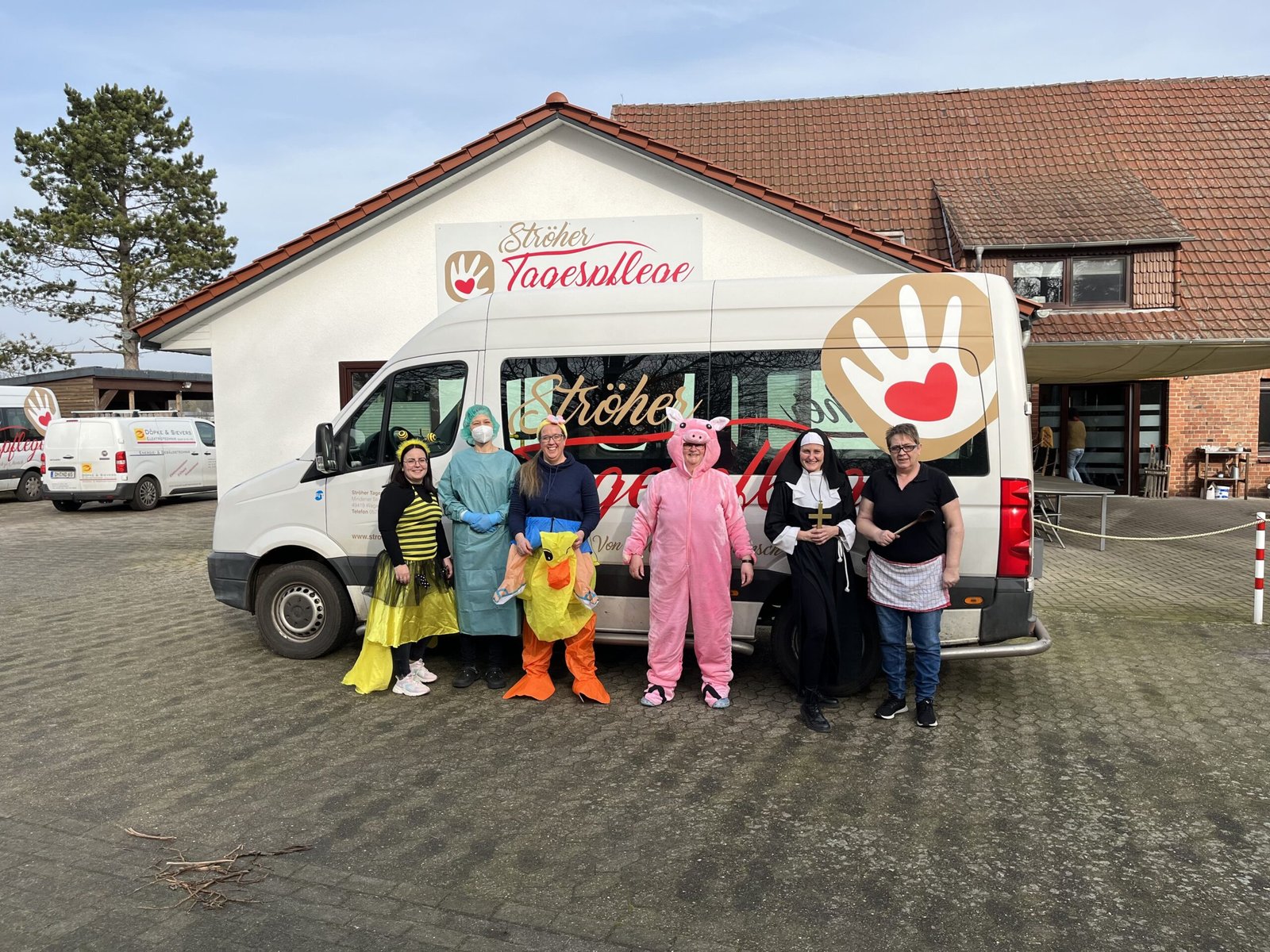 Gruppe in Faschingskostümen vor dem Fahrzeug der Ströher Tagespflege